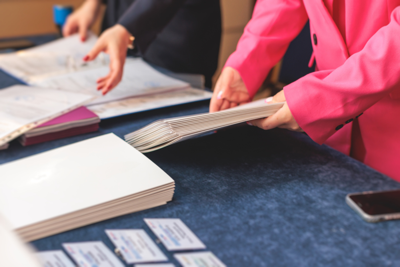 Process of checking in on a conference congress forum event, registration desk table, visitors and attendees receiving a name badge and entrance wristband bracelet and register electronic ticket